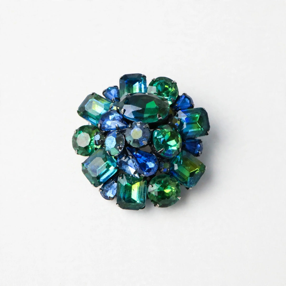 Signed Kramer 1950’s dimensional, domed, round cluster brooch with peacock colored faceted glass stones. Wow factor Sparkle!