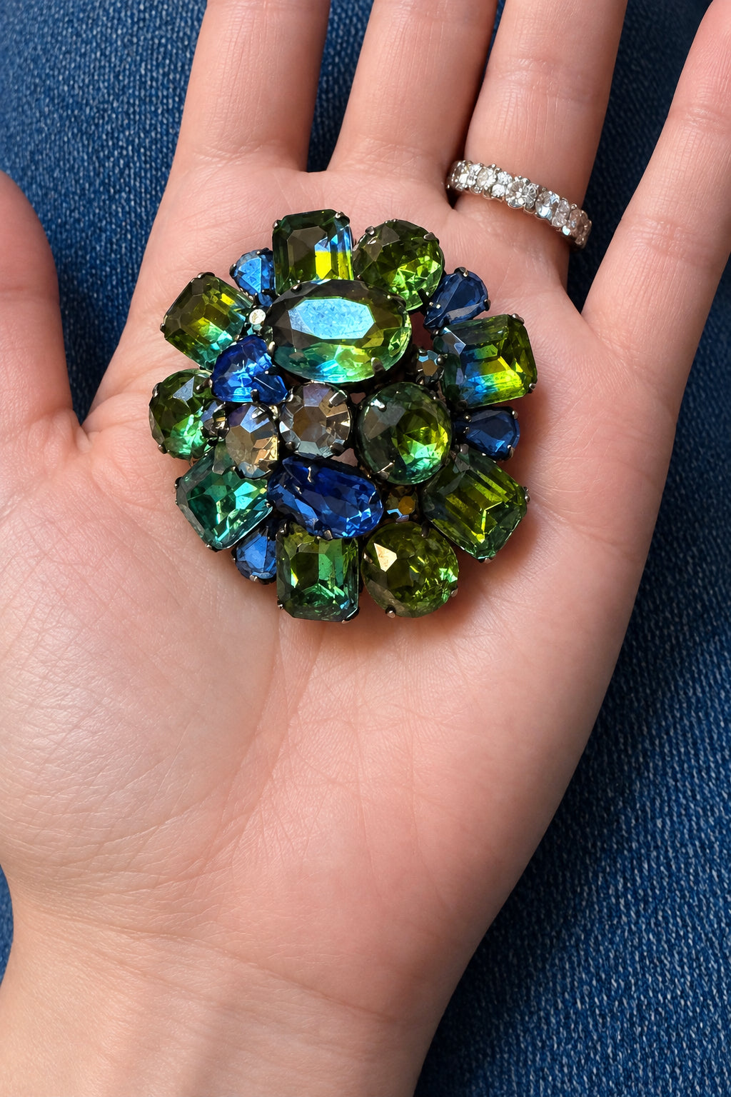 Signed Kramer 1950’s dimensional, domed, round cluster brooch with peacock colored faceted glass stones. Wow factor Sparkle!